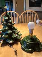 Vintage ceramic Christmas tree with base and bulb visible, showing unplugged state