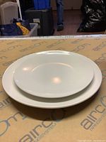 Stack of two plates showing difference in size with plain white smooth finish.
