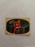 Front photo of 1962 Parkhurst hockey card showing Warren Godfrey in Detroit Red Wings uniform with large hockey puck background