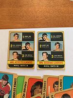 Photo showing NHL assists and scoring leaders cards for 1971/72 season featuring Bobby Orr, Phil Esposito, Jean Ratelle.