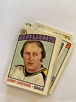 Photo showing stacked hockey cards with front card featuring Gerry Cheevers, Bruins goalie.