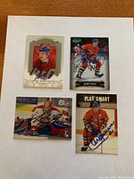 Four autographed hockey cards on white background showing Mike Komisarek, Bobby Smith, a goalie, and Montreal Canadiens player.