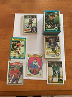 Stack and selection of vintage Topps hockey cards from 1970s and 1980s including visible players from several NHL teams.
