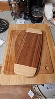 Stack of three wooden cutting boards showing different wood tones and sizes.