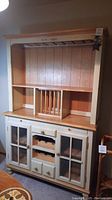 Full front view of the dining hutch showing the mesh door cabinets below, wine racks, drawers, and shelves above.