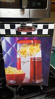 Box with image and branding of retro popcorn popper, showing 1950s style design and popcorn imagery.