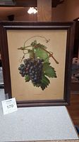 Wooden framed print of grape cluster artwork.