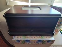 Dark wood Bombay jewelry box with beveled rectangular glass inset on top lid and a small knob drawer on front bottom side.