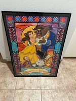Framed picture showing Beauty and the Beast Disney characters in stained glass style design.