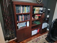 Bookshelf and credenza with multiple shelves, cabinets, and office supplies on shelves