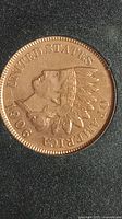 Close-up photo of the 1906 Indian Head penny showing the detailed profile of a Native American in a feather headdress and the inscriptions.