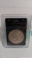 Front view of 1923 Peace Silver Dollar coin in protective case showing certification label and obverse design.