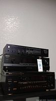 Three stacked stereo receivers, Kenwood on top, Sony in the middle, Denon on bottom.