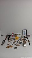 Overview of vintage watches, jewelry pieces and various small accessories laid out on a white background