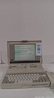 Front view of AST Advantage NB-SX25 vintage laptop displaying BIOS boot messages on screen.