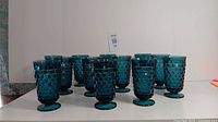 All 12 blue colony glasses arranged in rows showing consistent color and textured pattern