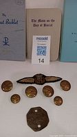 Group of four booklets, three leather craft stitch markers, brass buttons, cloth wing badge and brass tag