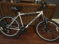 Left side profile of the Fuji Sundance 1500FS mountain bike showing frame, wheels, seat, pedals, and handlebar setup inside a room.