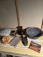 Overview of all items including porcelain dish, cups, glass vase, ceramic bowl, plastic box, binoculars, and landscape print.