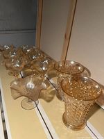 Two peach-colored textured glass vases and dessert dishes group under soft lighting