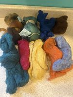 Full view of all assorted wool roving bundles in various colors on a countertop.
