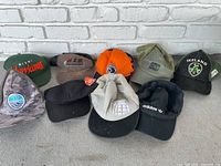 Lot of 10 adjustable ball caps, various brands and logos including Miami Hurricanes, Adidas, Ireland.
