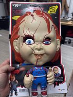 Front view of Chucky mask and matching figurine set on original Walmart packaging showing price $19.97 with horror picture design