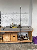 Full lot on table showing all items including anchor, outrigger rod/post, catch bag, and other fishing equipment.