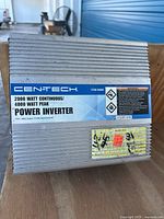 Top and side view of a rectangular silver aluminum power inverter with cooling fins and a blue and white Centech label stating 2000 watt continuous / 4000 watt peak power inverter.