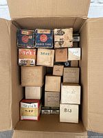 Top view of a box filled with various vintage vacuum tube boxes from brands RCA, Sylvania, and others, showing wear and original labels.