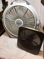 Large Wind Machine fan behind smaller O2 Cool fan, both visible showing size difference and design details