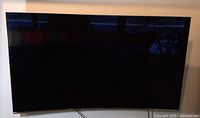 Front view of curved Samsung TV mounted on wall