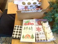 Small gift boxes with Christmas designs including red truck, trees, and 'Happy Holidays'. Some covered marshmallow-like white items included.