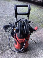 Full view of Kepma pressure washer from front showing handle, coiled hose, and spray gun.