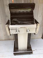 Front view, lid open, spatula on cooking grate
