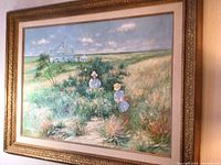 Framed impressionist painting showing French farmhouse scene with two young girls picking flowers in field.