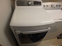 Front and top view of white Midea dryer showing control panel and door