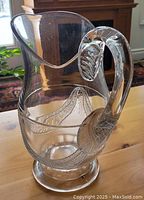 Clear view of the jug showing the draped garland pattern and leaf-shaped handle detail