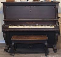 Front view of upright piano with visible wear and keys.