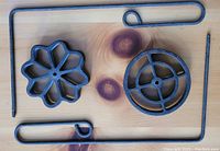 Top-down view of both flower and circular rosette irons side-by-side showing shapes and handles.