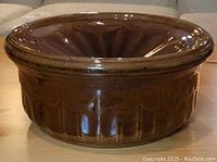 Side angle view of the brown ceramic spittoon showing textured exterior and glossy finish.