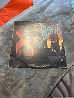 Front cover of the David Bowie vinyl album showing the singer with illuminated red lighting and the title Dance.