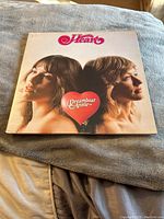 Front cover of Heart 'Dreamboat Annie' vinyl album showing close-up photo of two band members and album title with heart.
