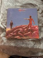 Front cover of Rush Hemispheres vinyl record showing original artwork with man in suit and nude figure on brain sculptures