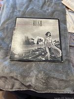 Front cover of the Rush self-titled vinyl LP album showing a woman standing in an outdoor setting in black and white.