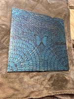 Front cover of Santana album showing blue butterfly and feather artwork with wear marks