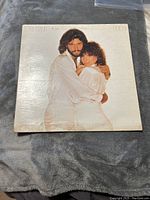 Front cover of the vinyl record album showing Barbra Streisand and Barry Gibb embracing in white outfits. Album title and artist names visible.