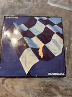 Front cover of The Cars Panorama vinyl record album with damage including tear and edge wear.