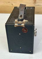 Front/side view showing leatherette body, strap, red window, winding knob