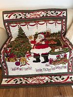 Full view of the Christmas quilt showing Santa Claus, tree, and gifts with 'Happy Holidays' blocks at the front